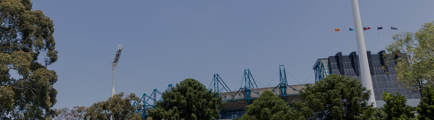 An image of the roof and light towers at the MCG with the blue sky in the background