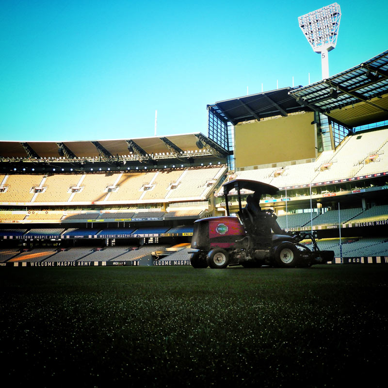 An arenas team member mows the turf