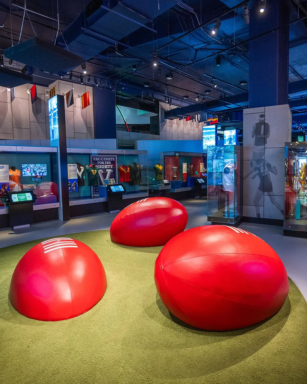 Giant footballs as seats displayed in sports museum.