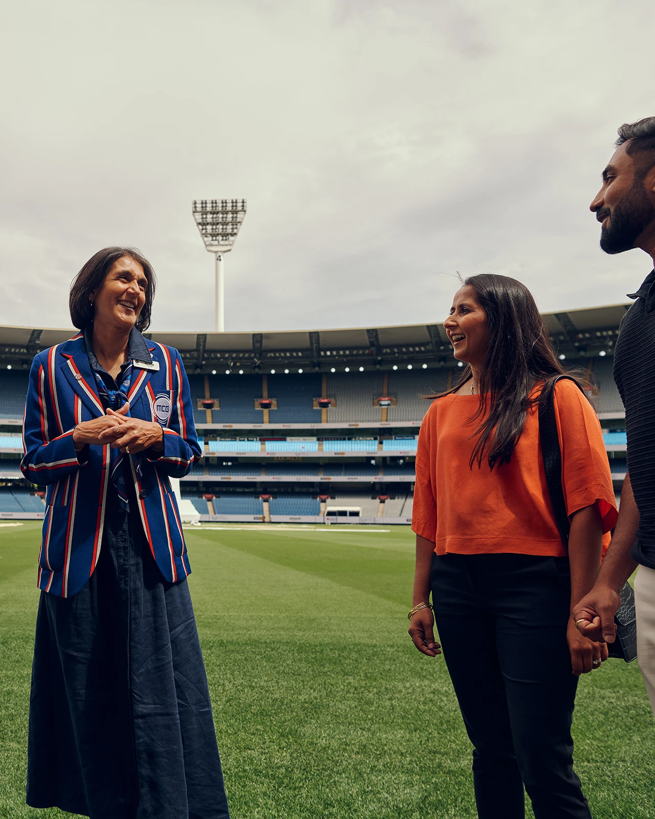 MCC tour guide speaks with visitors on MCG boundary
