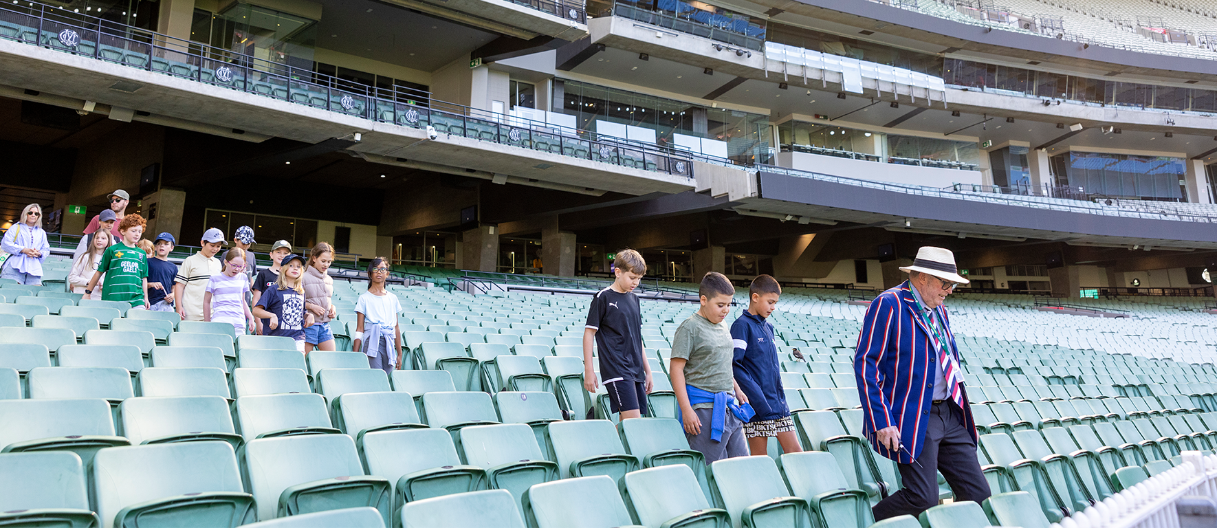 MCG Tours An MCG Tour Guide leads a school group into the seating bowl at the MCG