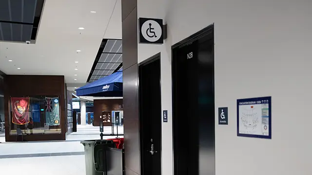 Black doors with wheelchair symbol to indicate an accessible toilet is inside.