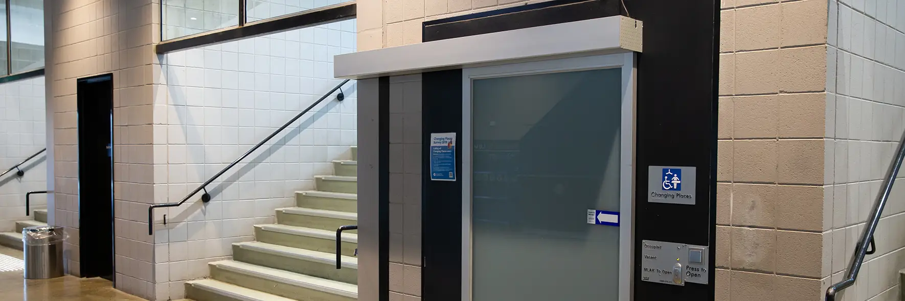 Facility with a wide, electric sliding door and Changing Places symbol.