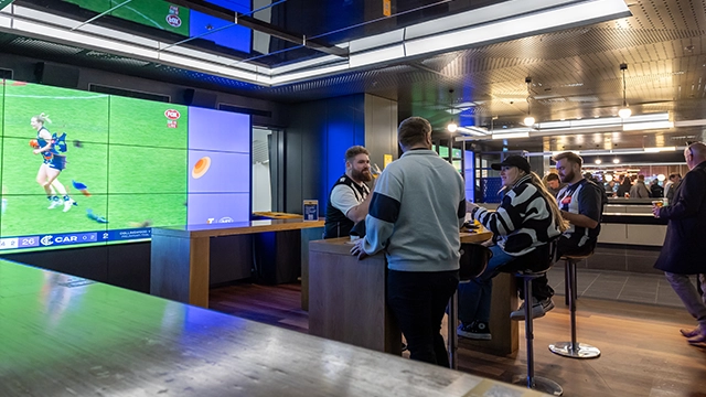 Fans drink beer next to the big screen in the Haydn Bunton Sports Bar at the MCG Fans drink beer next to the big screen in the Haydn Bunton Sports Bar at the MCG