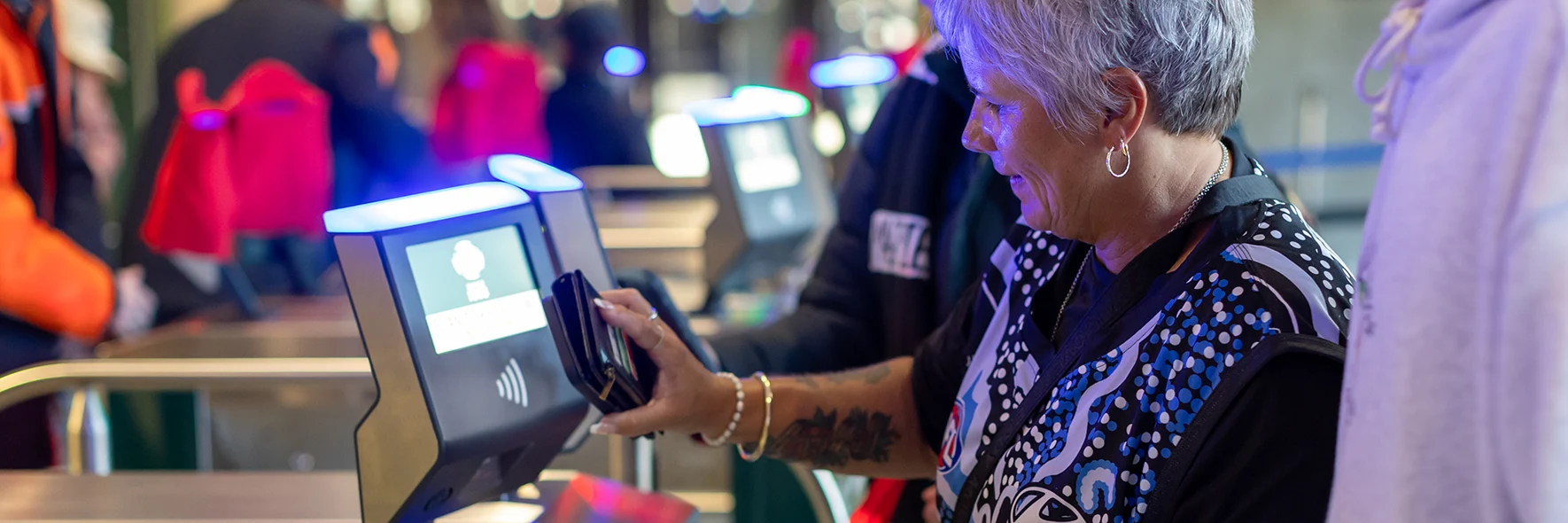 AFL supporter scans a phone against a ticket machine