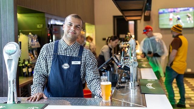 A Delaware North staff member serves a beer at the MCG A Delaware North staff member serves a beer at the MCG