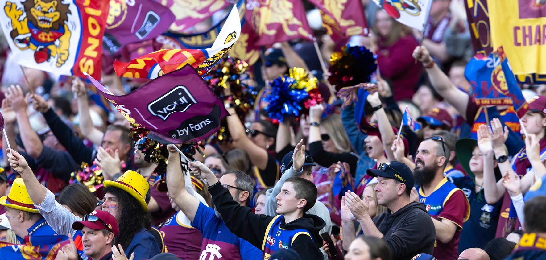 Crowd of Brisbane Lions supporters with flags