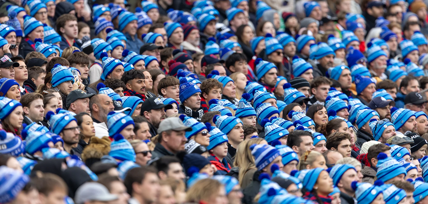 Packed MCG stand with patrons wearing blue Big Freeze beanies